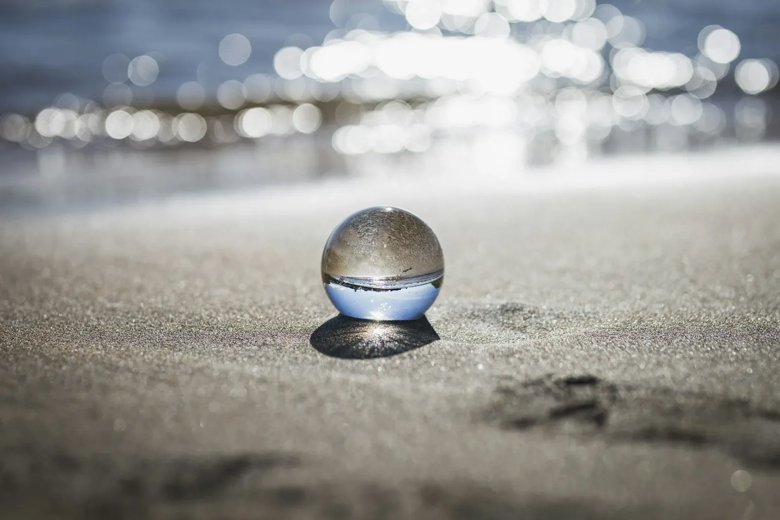 Glass sphere resting on sand, symbolizing creating inner space, clarity, and steadiness during the fertility journey